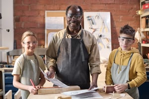smiling-kids-with-senior-black-carpenter-in-worksh-2026-01-08-00-16-00-utc